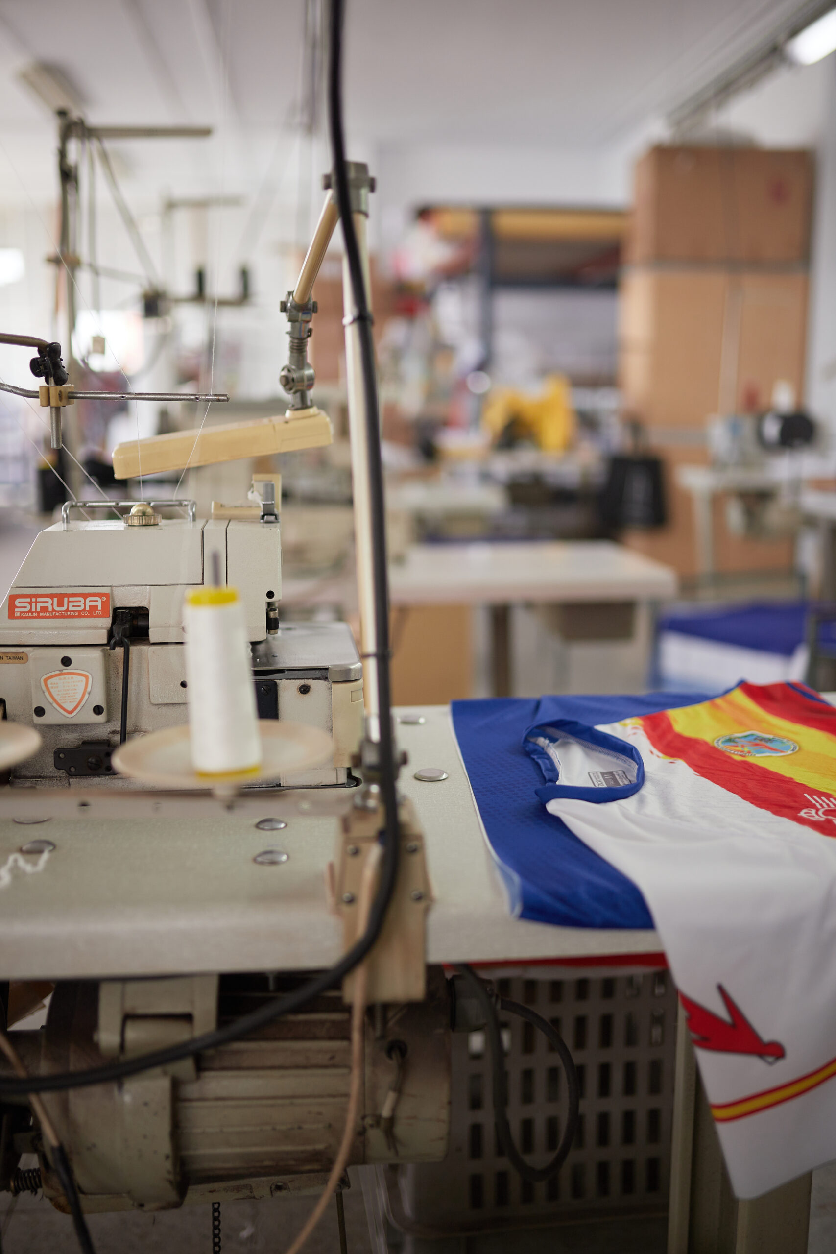 Máquina cosiendo bordes de una camiseta deportiva personalizada